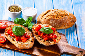 Bruschettas on cutting board on wooden background
