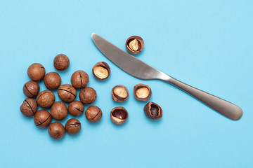 Shelled and unshelled macadamia nuts on blue background
