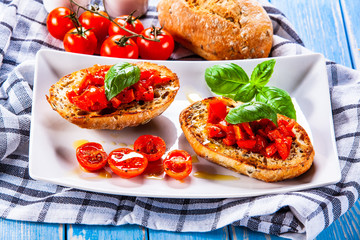 Bruschettas on cutting board on wooden background