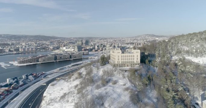 4K high angle aerial view of an old building used to train sailors with the Oslo skyline, The Munch Museum and the brand new Bj&oslash;rvika and Opera quarter, in the background.