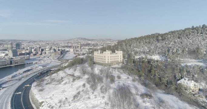 4K high angle aerial view of an old building used to train sailors with the Oslo skyline, The Munch Museum and the brand new Bj&oslash;rvika and Opera quarter, in the background.