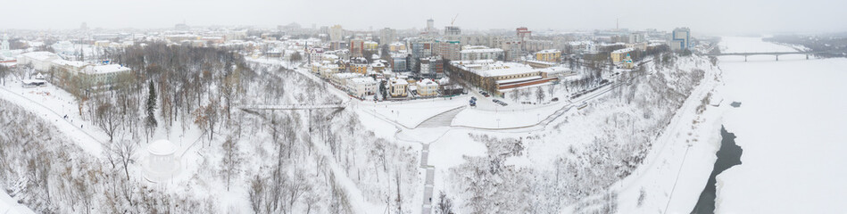 the city of Kirov and the high bank of the river Vyatka and the Alexander Grin Embankment and the rotunda on a cloudy winter day.