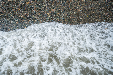 Top view of stone beach with small waves