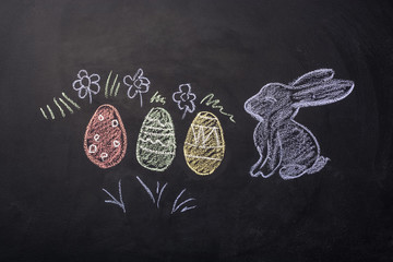 easter eggs and rabbit painted on chalk board