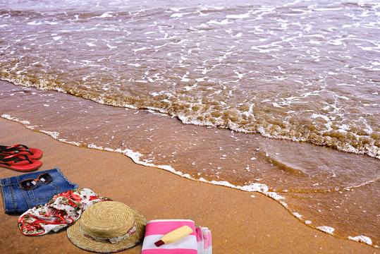 Summer Beach accessories laying on sand in empty sea beach