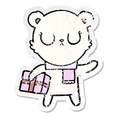 distressed sticker of a peaceful cartoon polar bear with christmas gift