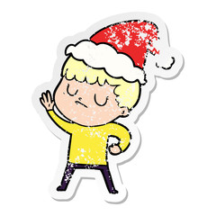distressed sticker cartoon of a grumpy boy wearing santa hat