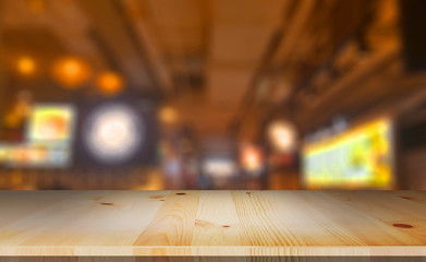 Wood table top and blurred background food of restaurant.