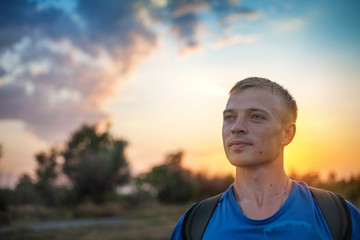 Portrait of a man with standing outdoors in the evening.