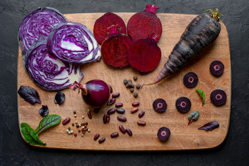 Fototapeta na wymiar Sliced purple vegetables on a wooden cutting board. Top view