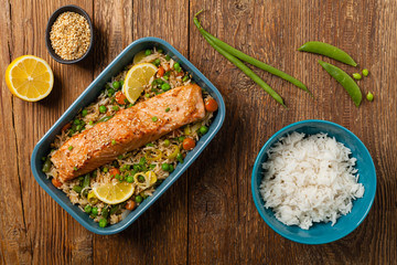 Asian dish. Fried salmon with rice and vegetables. Sprinkled with sesame seeds.