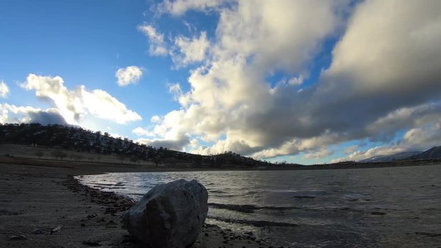 Cloudy time lapse over river at sunset