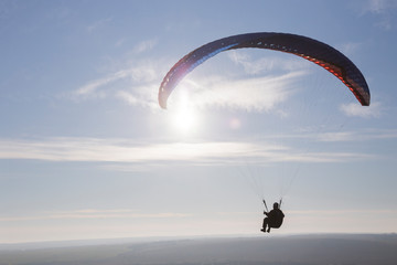Paraglide with a paraglider in a cocoon against the background of fields of the sky and clouds....