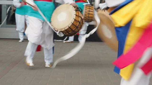 Korean national festival. A group of musicians and dancers in bright colored suits perform traditional Korean folk dance Samul nori Samullori or Pungmul and play percussion Korean musical instruments