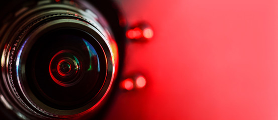 Camera lens and red backlight . Horizontal photography. Banner