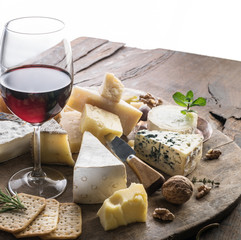 Cheese platter with organic cheeses, fruits, nuts and wine. Tasty cheese starter.