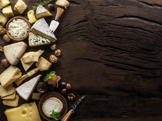 Assortment of different cheese types on wooden background. Top view.