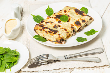 Cannelloni with minced beef and spinach baked in béchamel sauce. 