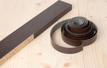 the edges of melamine chipboard on wooden background