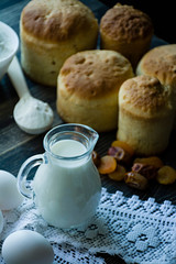 Carafe with milk in the background Easter cakes on a dark background. Fresh cakes with dried fruits. The process of cooking Easter cake. View from the side.