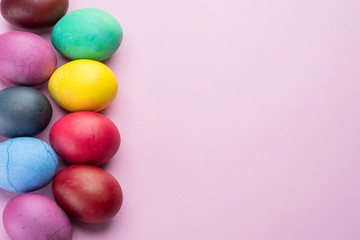 Colorful Easter eggs as an attribute of Easter celebration. Pink background.