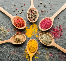 Assortment of colorful spices in the wooden spoons.