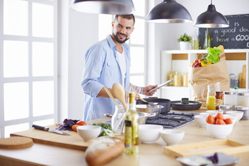 Smiling and confident chef standing in large kitchen