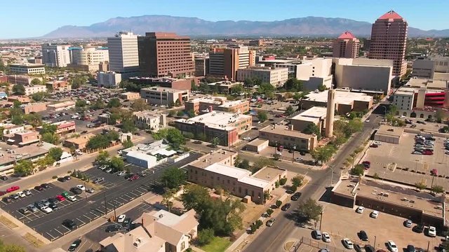 Aerial sidewards shot, showing downtown Albuquerque on a sunny day.