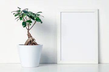 Fototapeten Shelf at home against a white wall. A mockup frame with space for text or graphics. A bonsai decoration in a white pot. Scandinavian style. © Ester_K