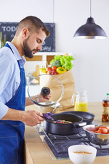 Smiling and confident chef standing in large kitchen