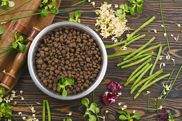 Special vegan pet food and natural raw ingredients on brown wooden background. Flat lay.