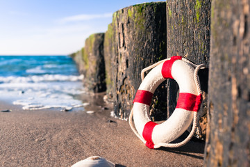 Nostalgic Life Buoy Beach Sea Shore Scene / Vintage red and white miniature life buoy at row of...