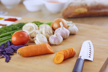 Composition with wooden board and ingredients for cooking on table