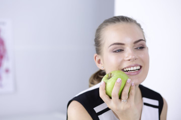 Young beautiful smiling girl with a green apple in hands