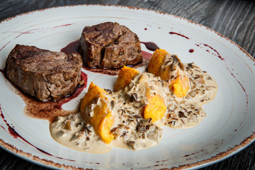closeup two pieces of grilled meat steak with blood with potato zrazy