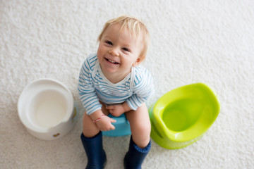 Cute toddler boy, potty training, playing with his teddy bear