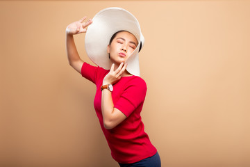 Portrait woman wearing big hat isolated on brown beige background