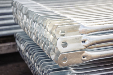 Galvanized metal elements of scaffolding folded in a pallet close-up.