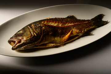 Grilled fish served on a plate in restaurant