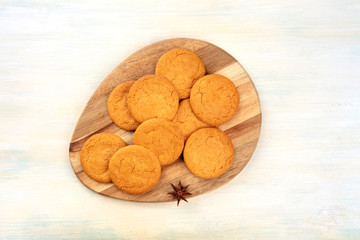 Gingersnaps on a wooden tray, shot from above with an anise star and copy space