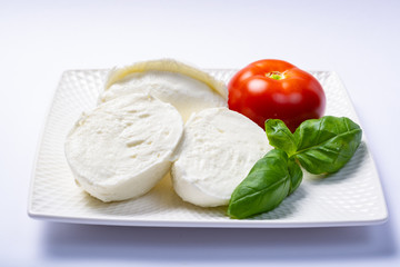 Soft white Italian cheese Mozzarella buffalo served with fresh tomato and green basil leaves