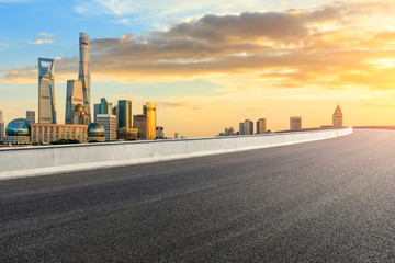 Obraz premium Empty asphalt road through Shanghai business district at sunset