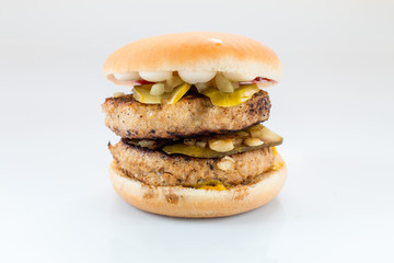 cheeseburger with beef cutlet, bacon, tomatoes and cheese slices, seasoned with sauce and green salad for a restaurant menu on a white isolated background