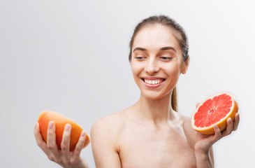 Lovely girl with grapefruit slices in her hands