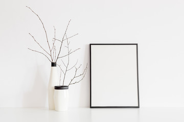 Frame and decorative twigs in a design vase.