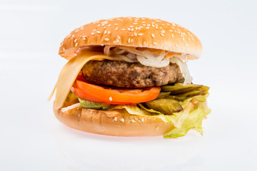 cheeseburger with beef cutlet, bacon, tomatoes and cheese slices, seasoned with sauce and green salad for a restaurant menu on a white isolated background