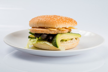 cheeseburger with beef cutlet, bacon, tomatoes and cheese slices, seasoned with sauce and green salad for a restaurant menu on a white isolated background