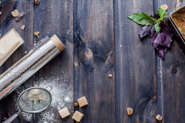 Cooking dough, cooking equipment, flour on a wooden table. Top view with copy space, mockup for menu, recipe. Baking background.