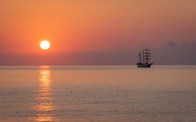 Sail ship off the coast of Mallorca anchored in the Mediterranean sea at sunrise.