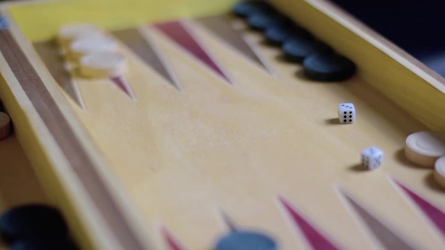 Player of backgammon throws dices on backgammon table. Close up footage